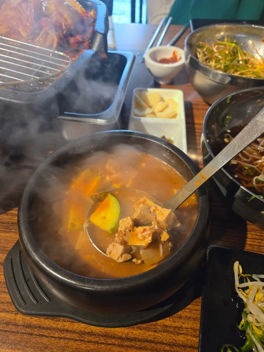 Table packed with meat, steamed egg, and doenjang jjigae