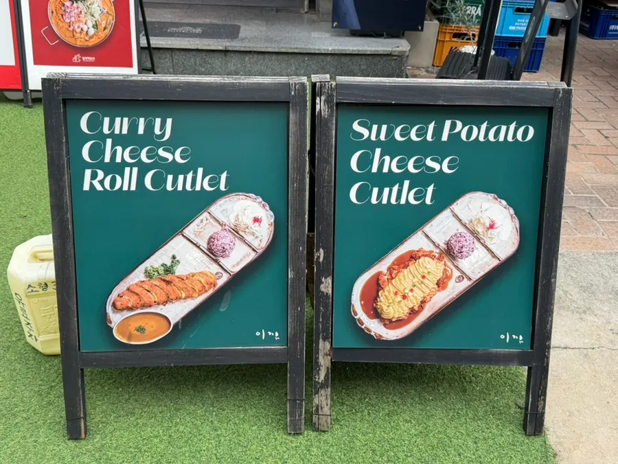 Standing sign at the entrance showing Ikki Roll Katsu's signature menu items
