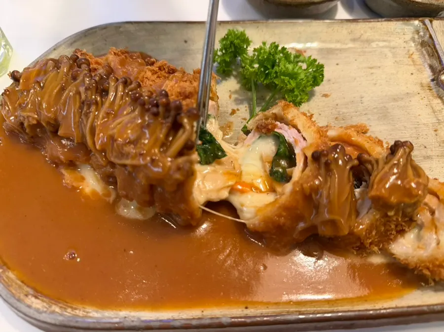 Roll katsu served with black rice and lettuce salad