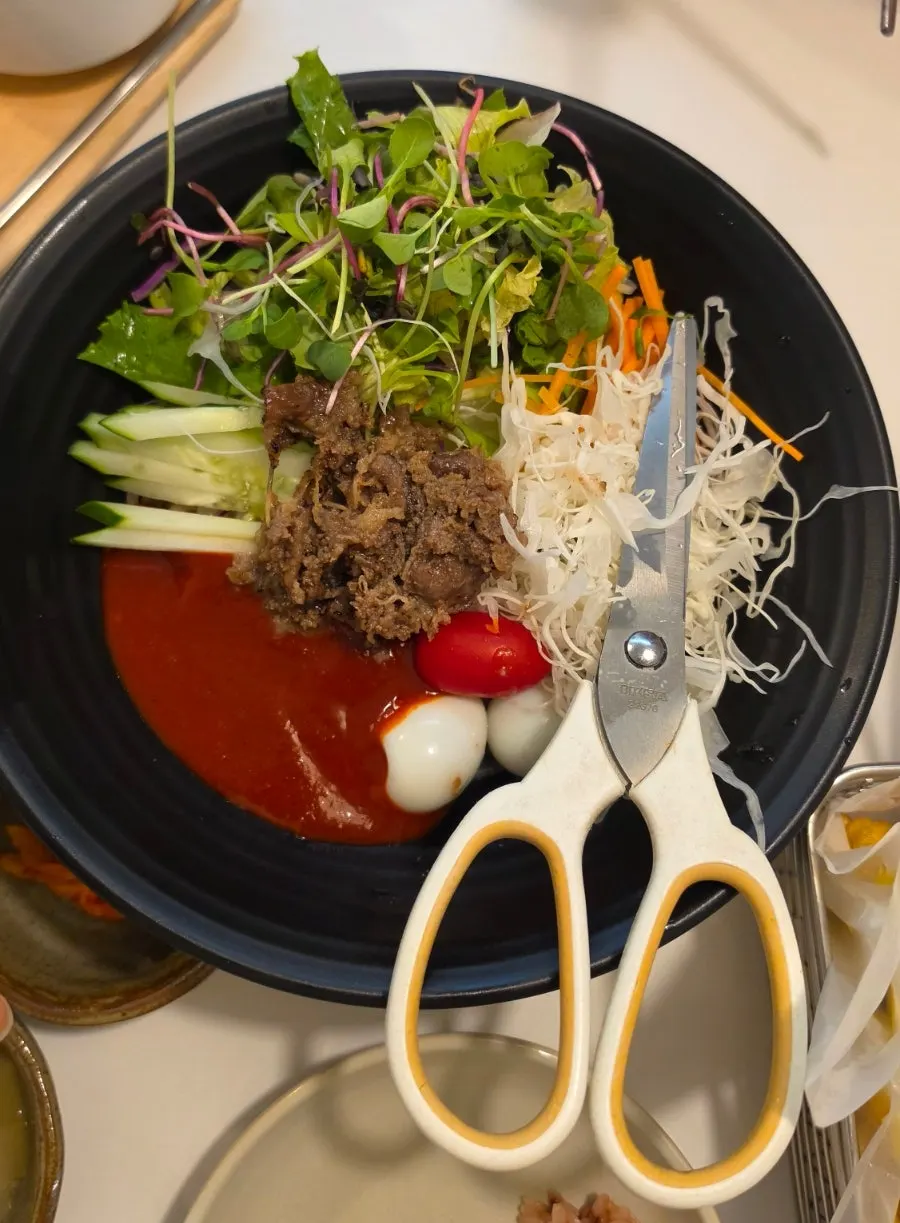 Charred beef brisket jjolmyeon topped with vegetables
