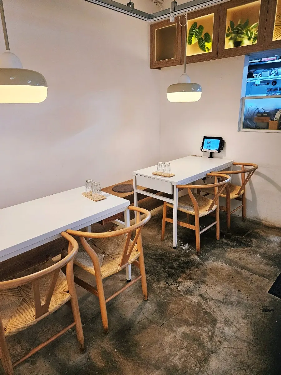 無垢材のテーブルと椅子が並ぶ店内
