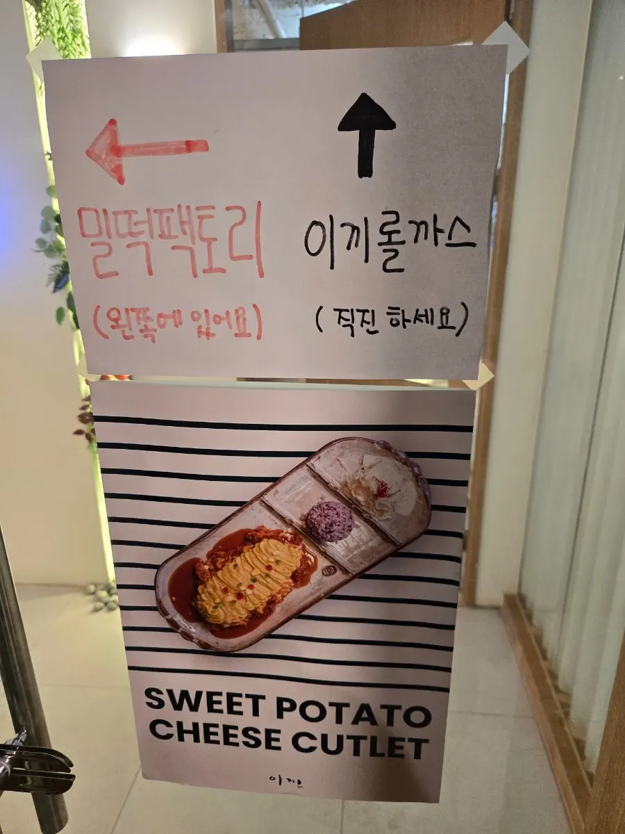 Sign showing Ikki Roll Katsu and Miltteok Factory side by side in the basement