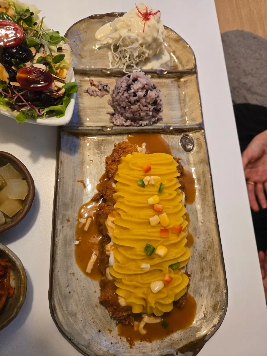 A full pork cutlet spread with cabbage salad piled high