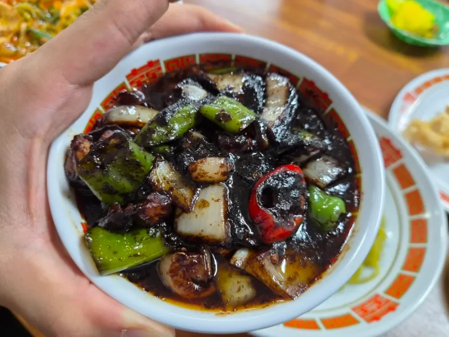 A bite of samseon jjamppong showing the beef bone broth