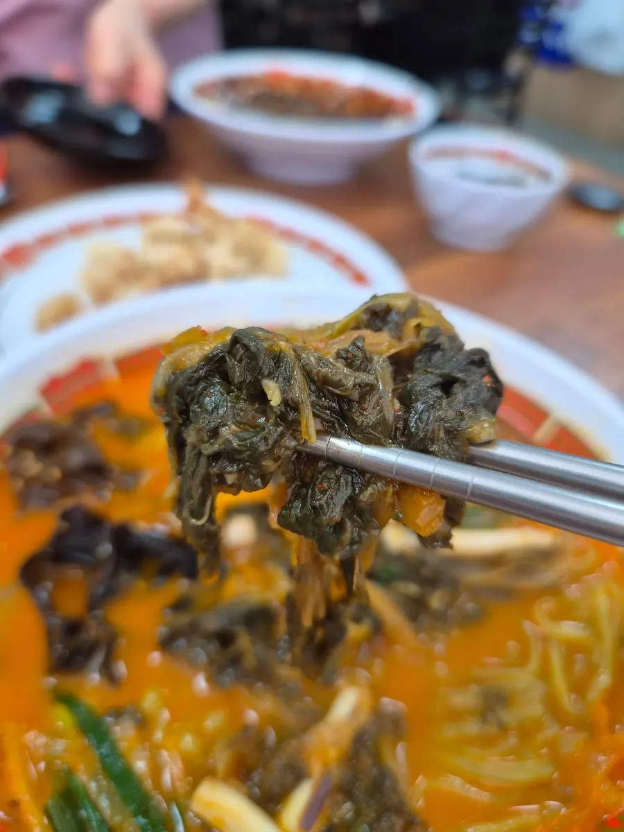 Jjamppong broth topped with wood ear mushrooms and vegetables