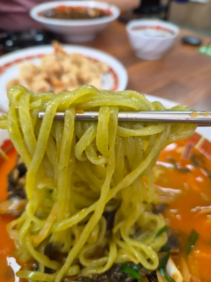 Chewy chive noodles lifted out of the jjamppong