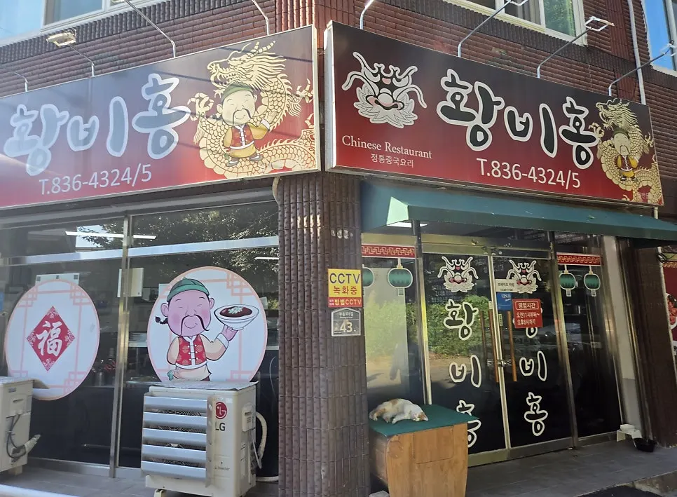 Sign for Hwangbihong Chinese cuisine tucked in a neighborhood alley