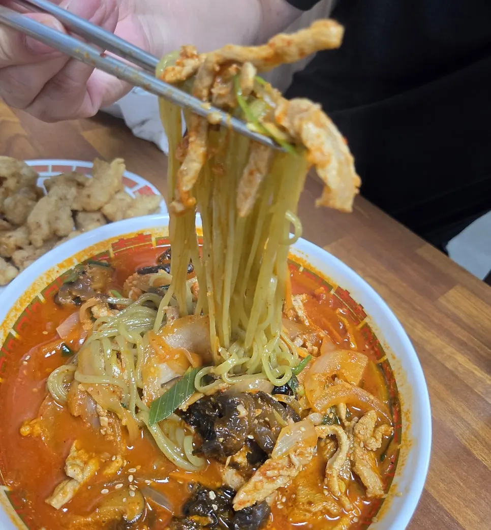 Close-up of jjamppong noodles being lifted