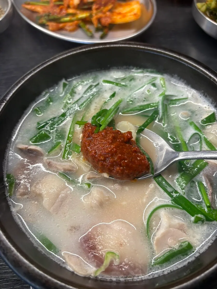 A spoonful of gukbap broth lifted up