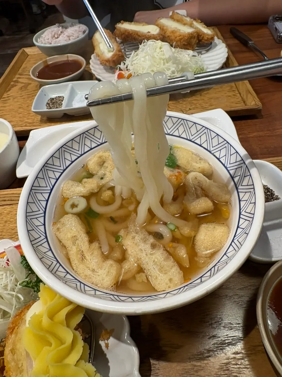 Cross-section of sweet potato cheese katsu and bowl of udon