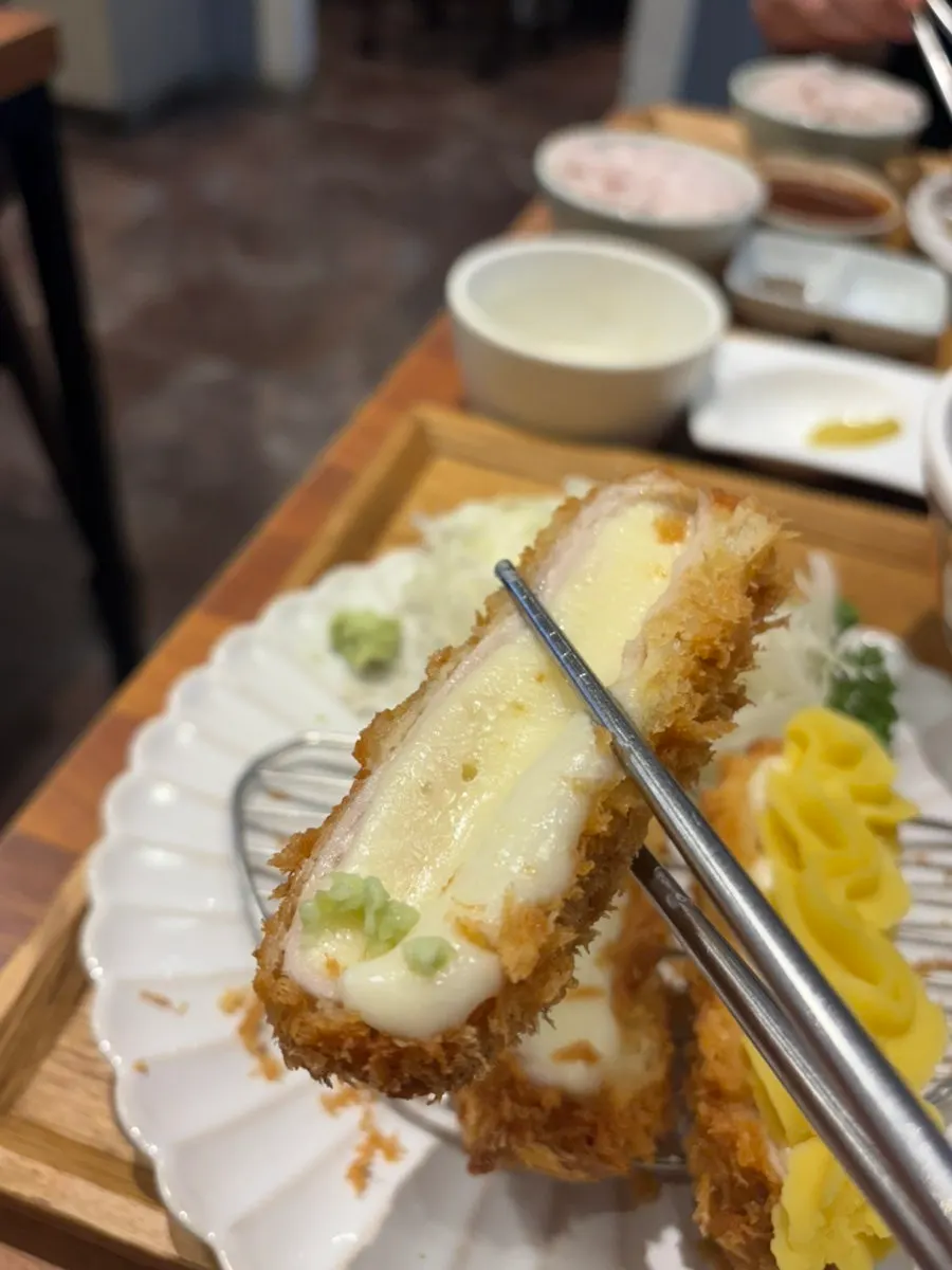 A piece of katsu with dipping sauce on the side