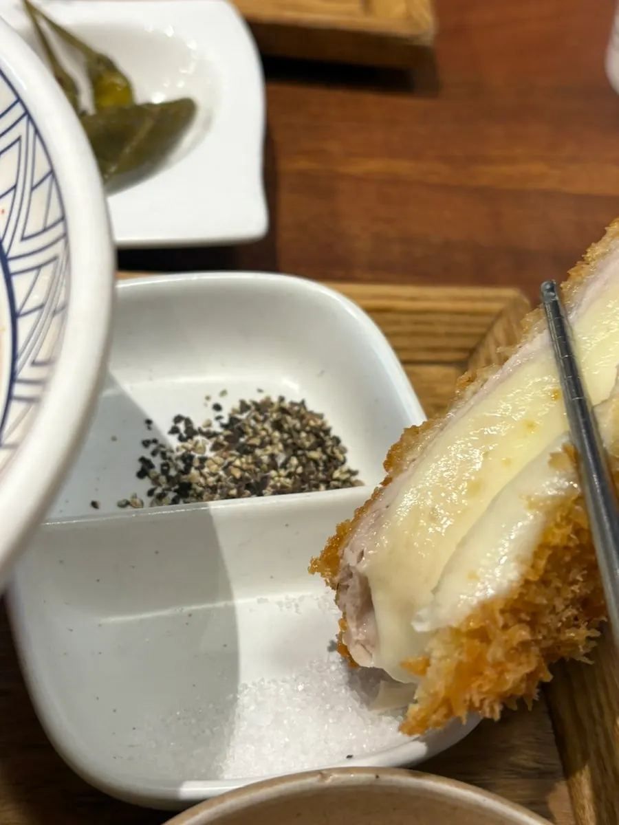 A piece of tonkatsu topped with wasabi and salt