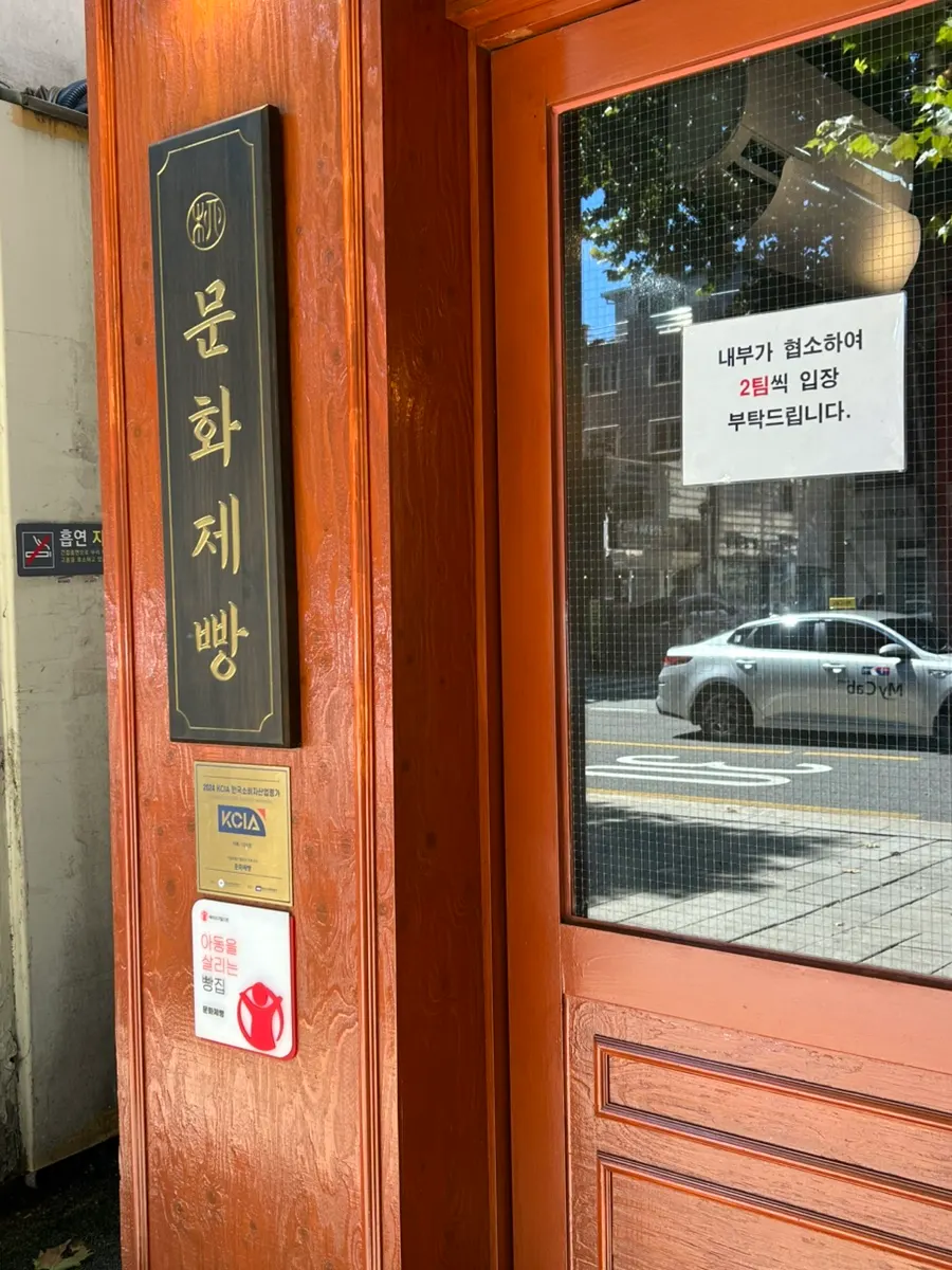 Entrance signage noting Munhwa Bakery is takeout only