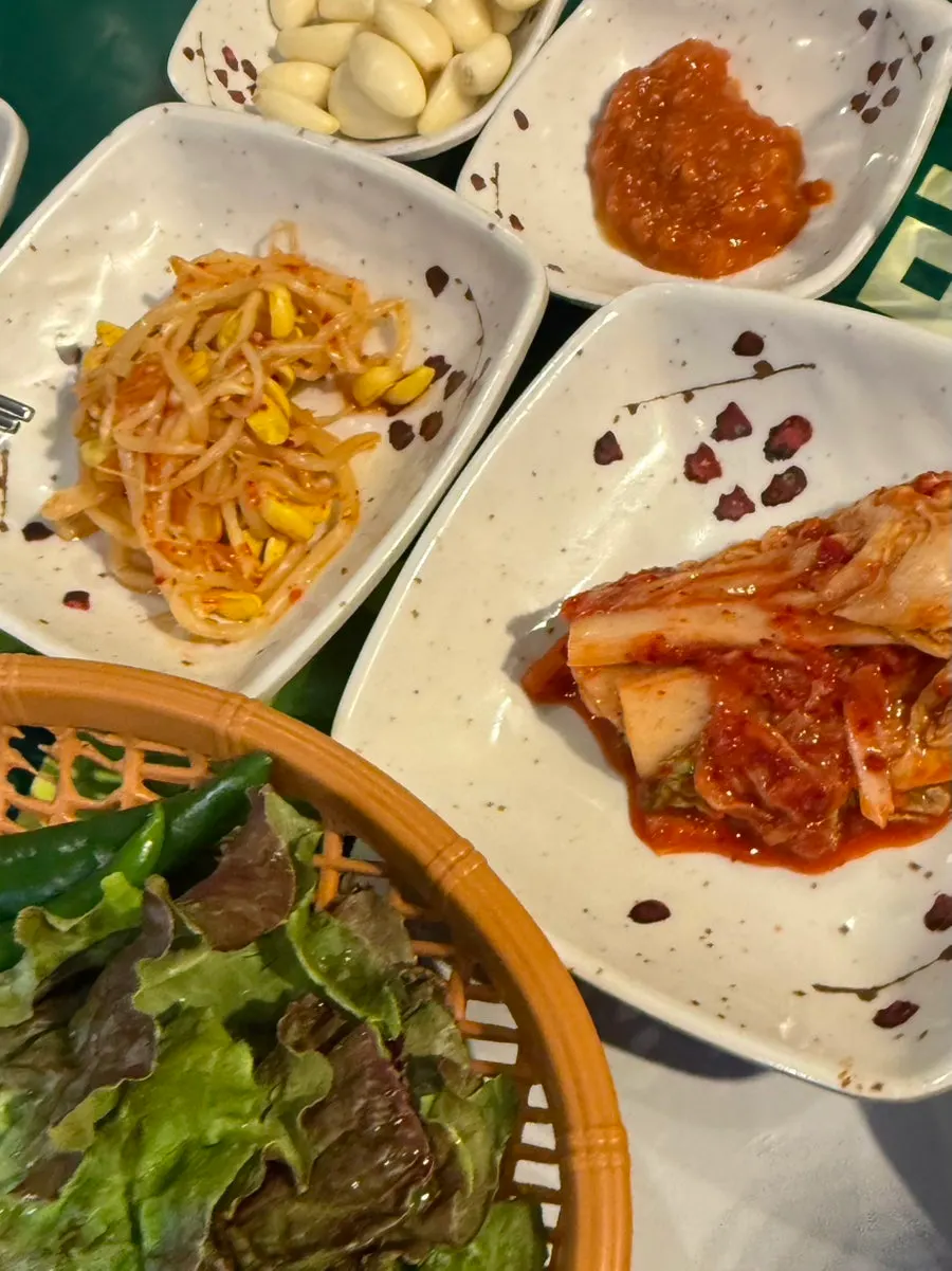 Basic side dishes: bean sprouts, kimchi, garlic, and lettuce wraps