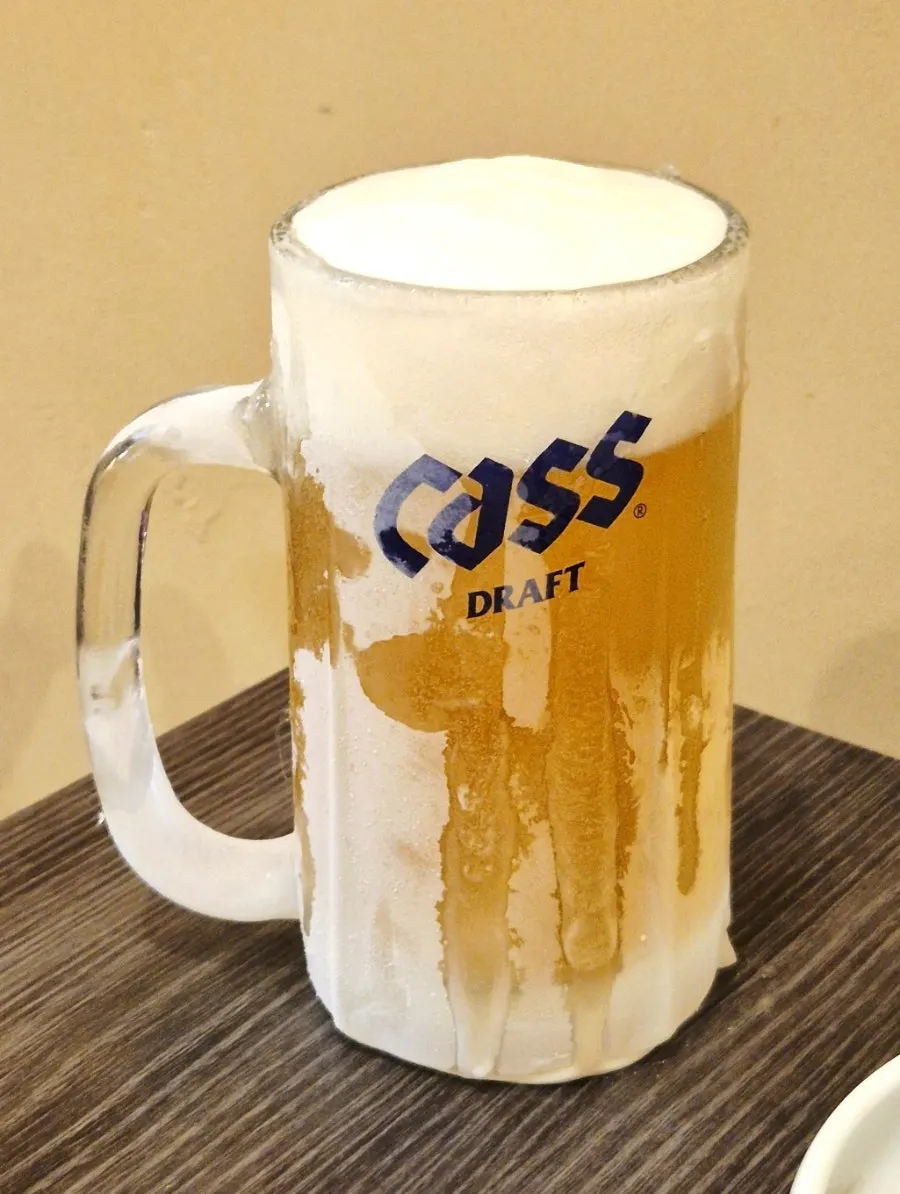 A glass of draft beer with ice