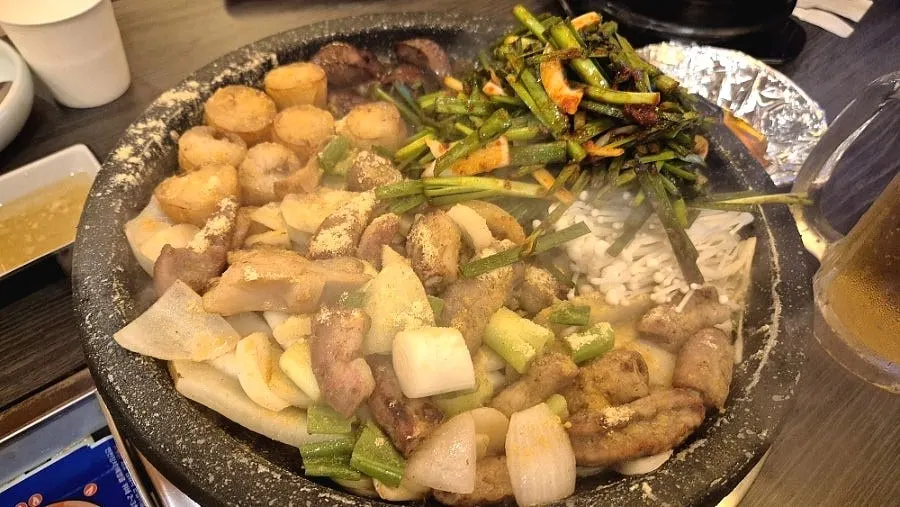 A grill plate served with chives and enoki mushrooms