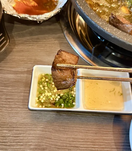 두툼하게 구워진 염통을 소스에 찍은 모습