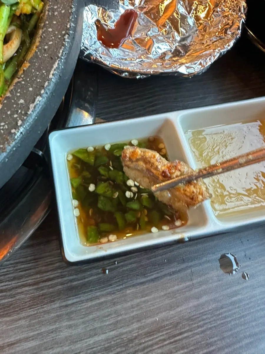불판 위 곱창과 곁들임 소스