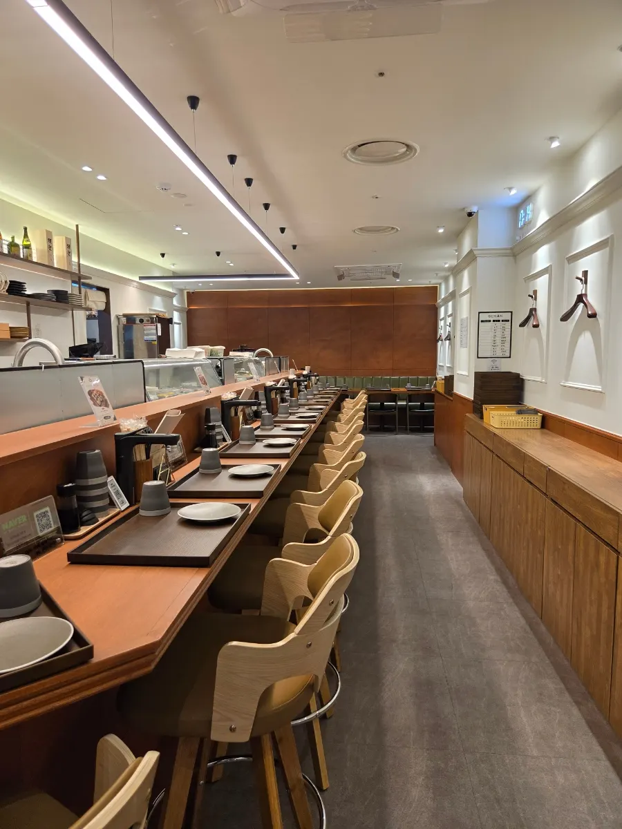 White and wood-toned interior with a long row of bar seats