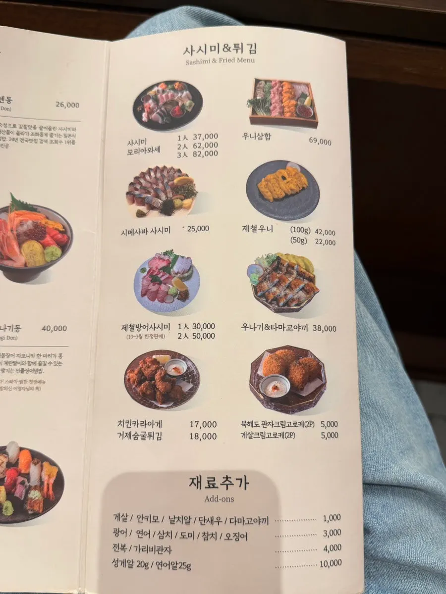 Menu listing sashimi, tempura, and ingredient add-on prices