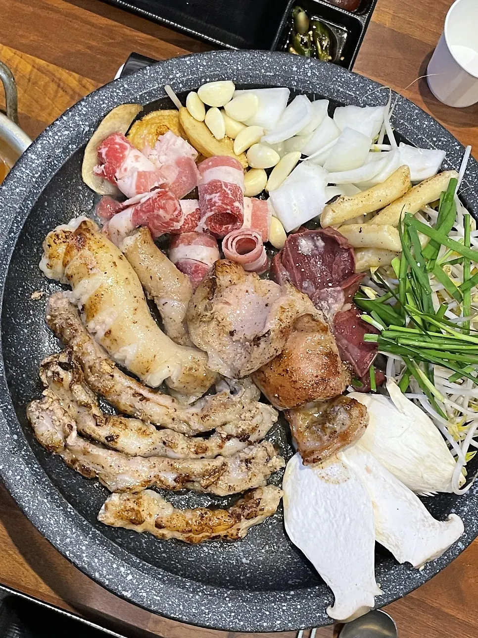 Grill loaded with gopchang, rice cakes, bean sprouts, and chives