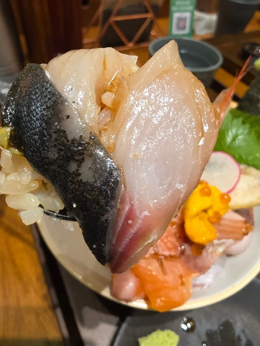 A bite of premium kaisendon on gamtae seaweed