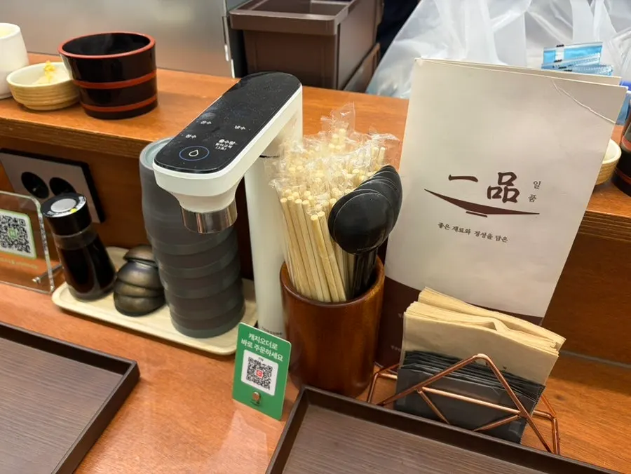 메뉴판과 수저, 자리 정수기가 놓인 테이블