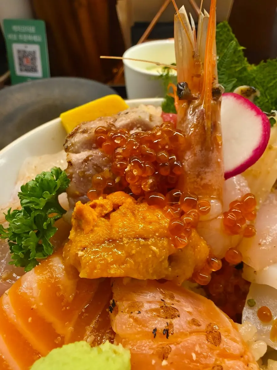 Picking up a piece of kaisendon sashimi