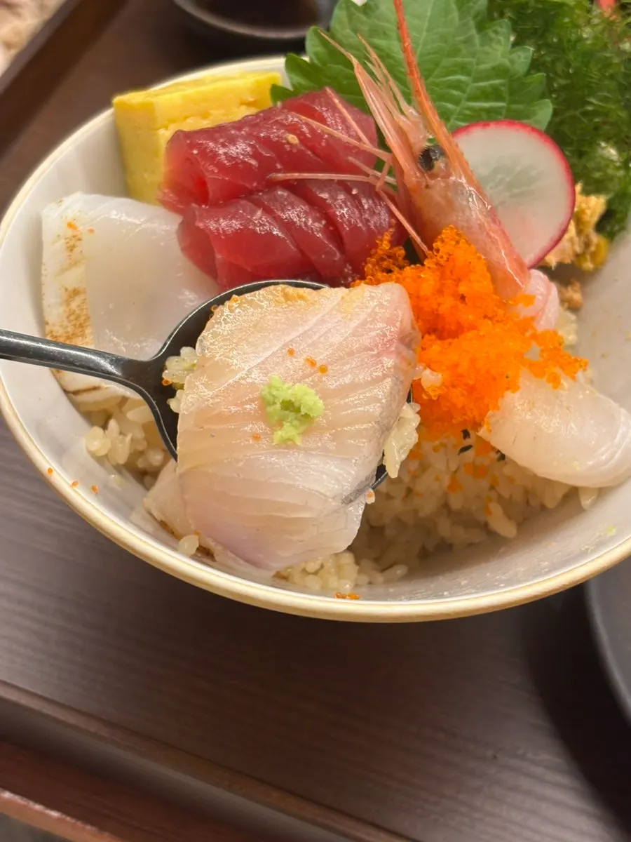 A bite of kaisendon eaten with rice