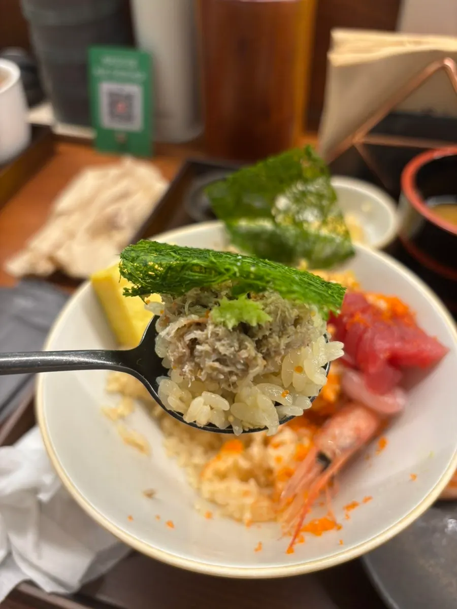A bite of kaisendon topped with gamtae