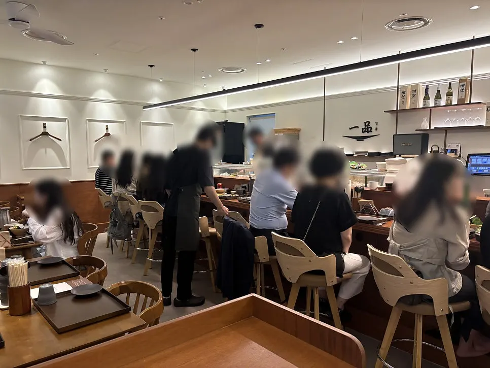 일품 로고와 사케 병이 놓인 매장 벽면