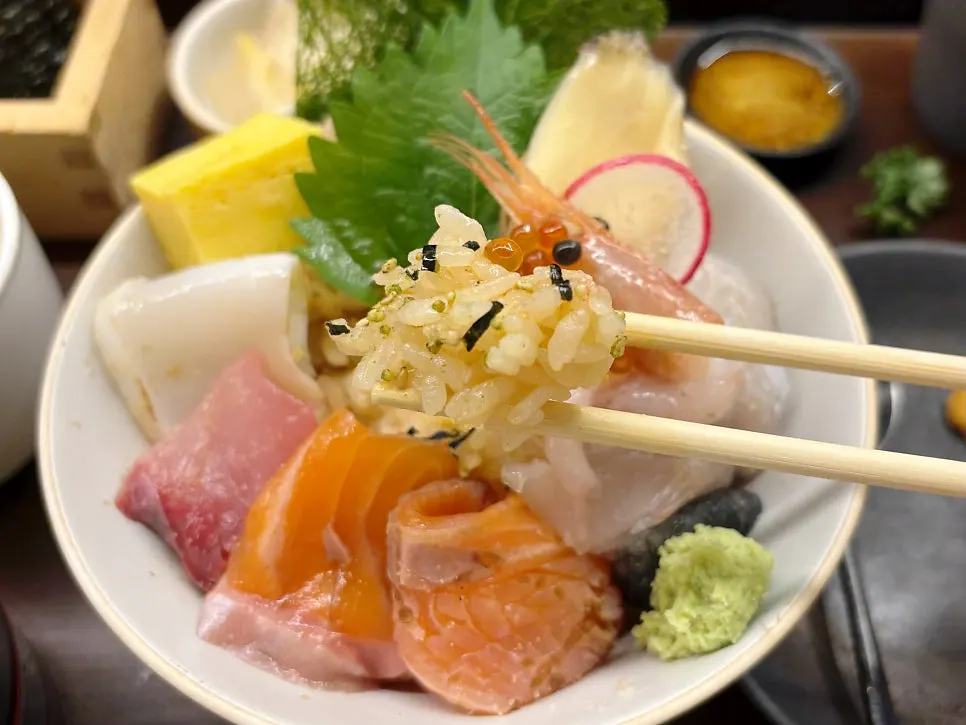 Scooping rice and sashimi together