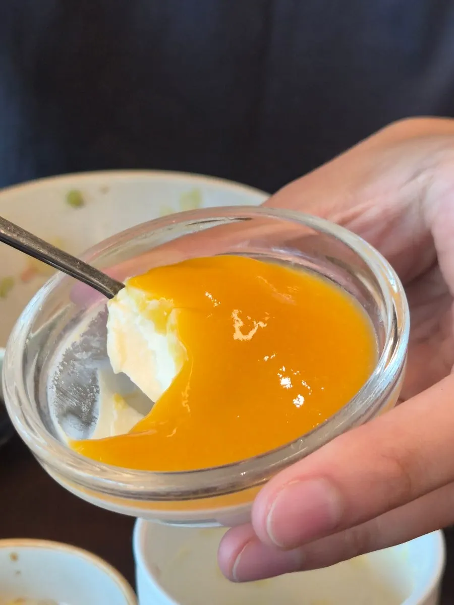 A spoonful scooped out of the mango pudding