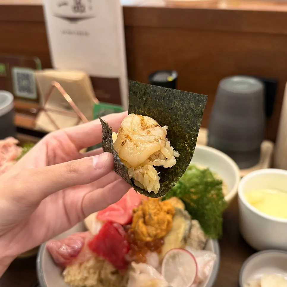 A piece of sashimi wrapped in seaweed from the premium kaisendon