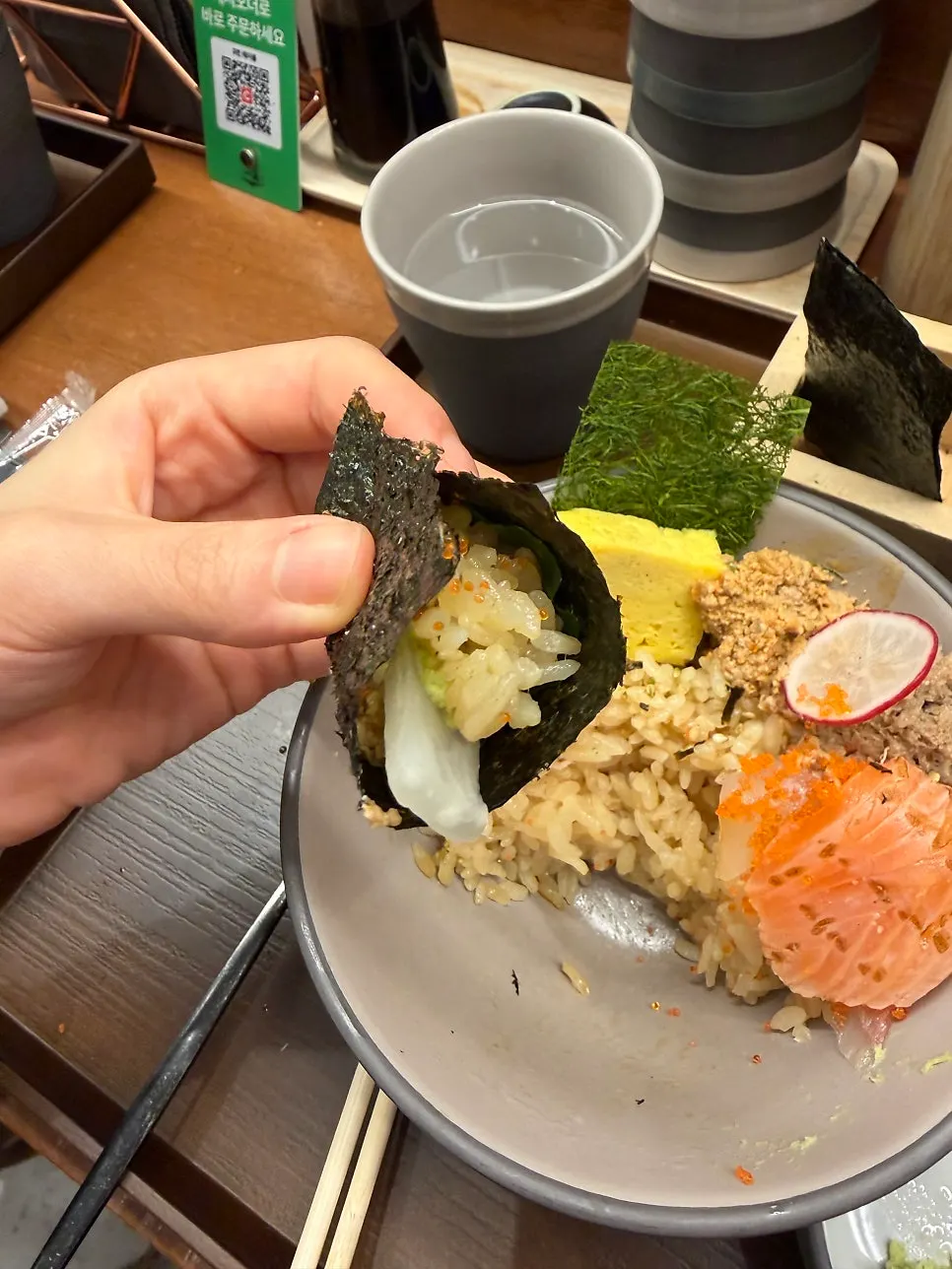 Wrapping kaisendon sashimi and rice in seaweed to eat