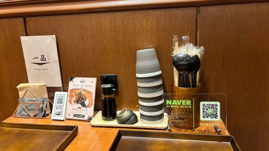 Table setting with water, utensils, soy sauce, and wet wipes