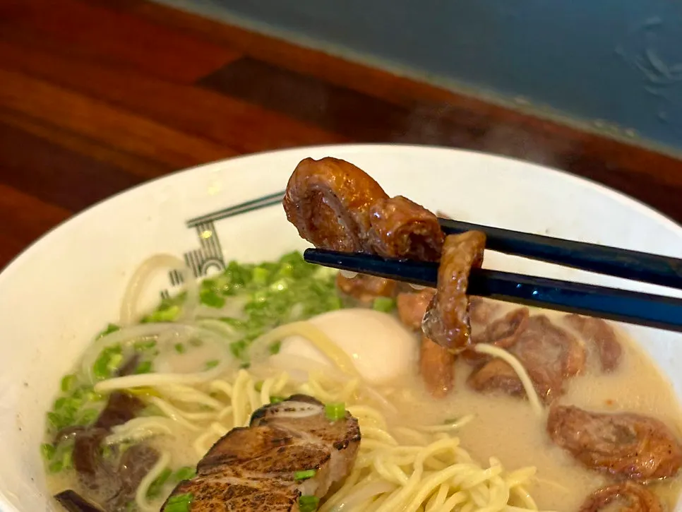 A spoonful lifting both gopchang and chashu from the Motsu Ramen