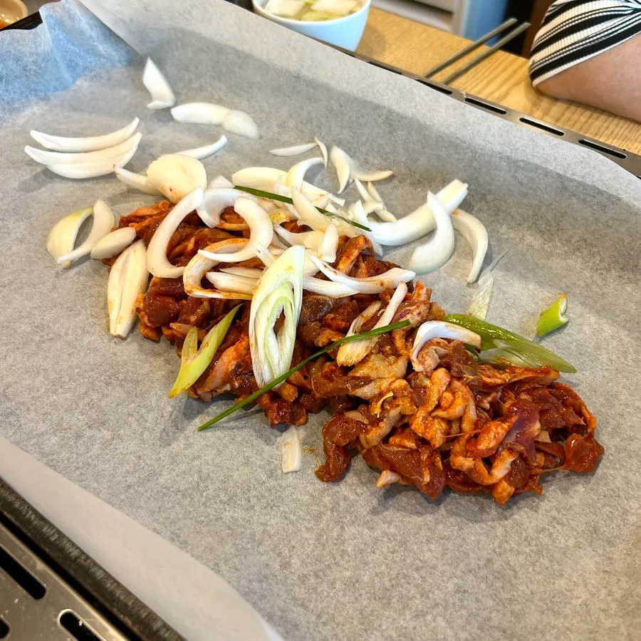 Spicy stir-fried duck and vegetables spread on a griddle