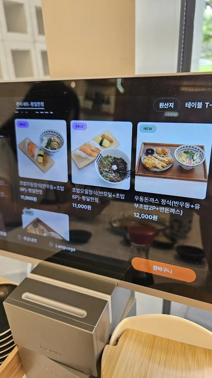 Menu board listing rice bowls, sashimi, and side dishes