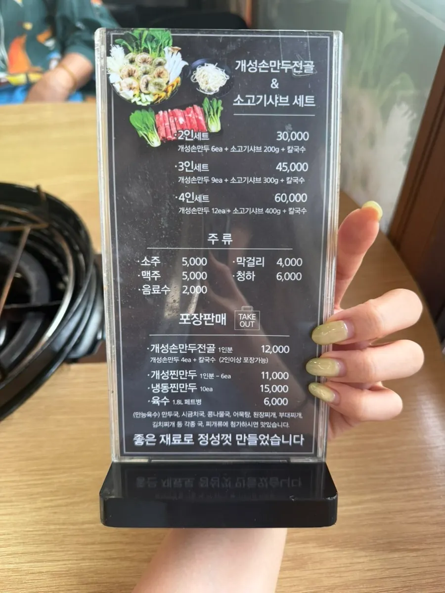 Menu board listing gaeseong sonmandu hot pot and meat dishes