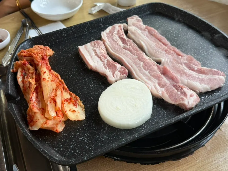 Side dishes including pickled onion, shredded scallion, and seasoned bean sprouts