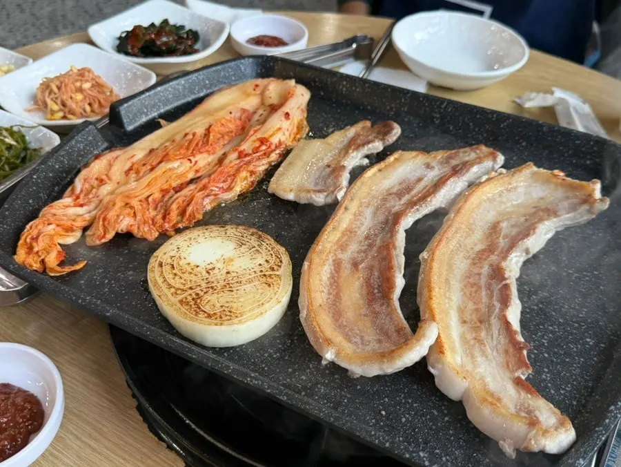 Domestic fresh ogyeopsal, kimchi, and onion on the grill