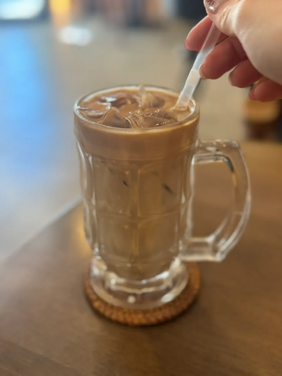 Iced latte placed alongside brunch dishes