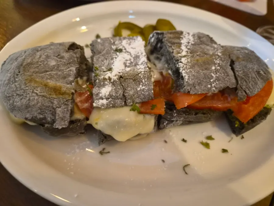 Corte del basil tomato cheese panini con el queso estirándose