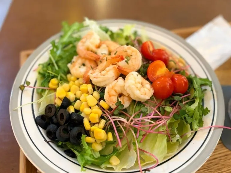 Table with whole shrimp salad and Americano