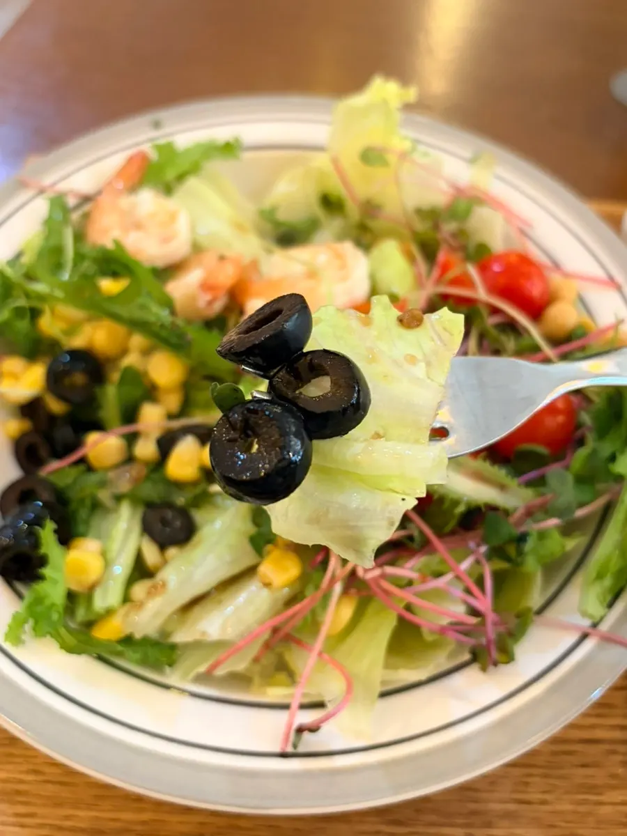 Whole shrimp salad showing black olive topping