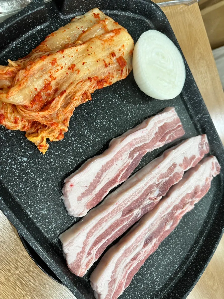 Ogyeopsal, kimchi, and whole onion on the grill