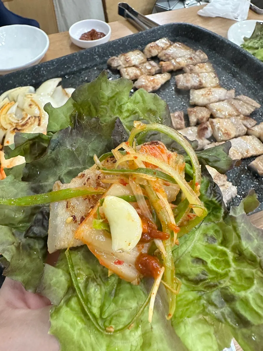 Lettuce wrap with ogyeopsal, kimchi, and shredded green onion