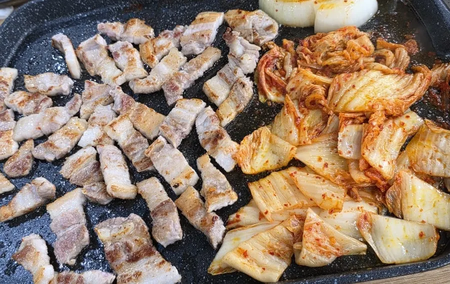 불판 위에서 기름을 머금은 김치