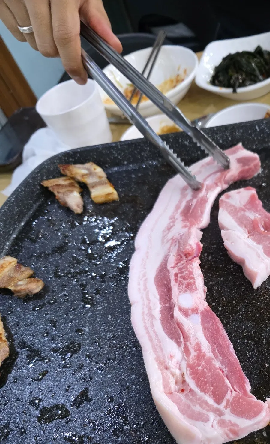 익어가는 삼겹살을 집어 든 모습